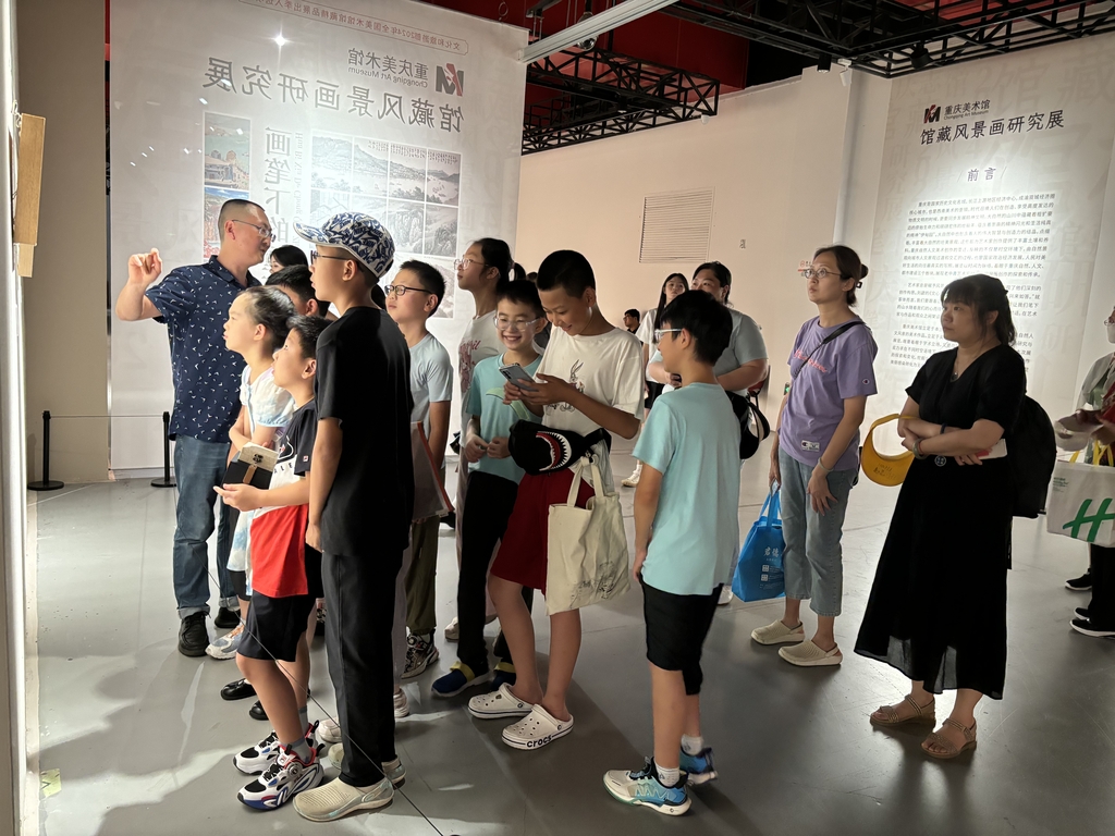 重庆美术馆（重庆画院）副馆长唐徳福正在为小观众们导览讲解