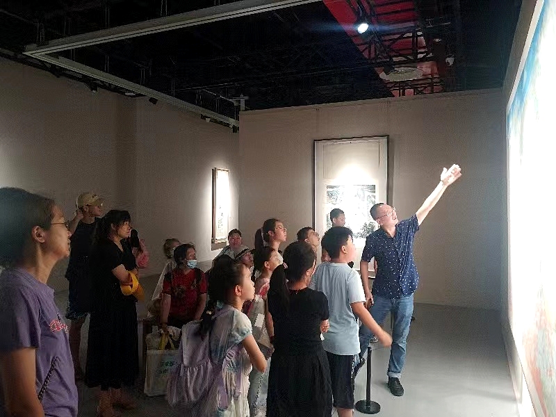 展览现场的小观众正在聆听艺术作品背后的故事