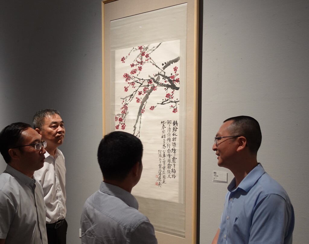 重庆美术馆（重庆画院）副馆长、副院长唐德福向观展嘉宾介绍展出中的冯建吴作品